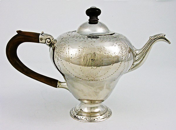 A silver teapot from around the mid-18th century, with a bulbous body, curved handle, and short spout